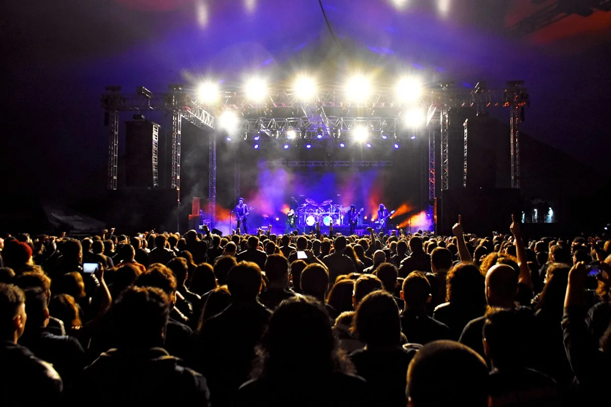 A concert stage and audience under atmospheric lights
